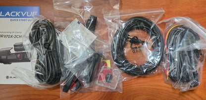 BlackVue device with cables and accessories on a wooden surface